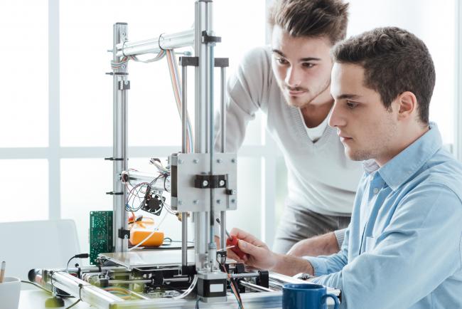 To menn jobber med en 3D-printer