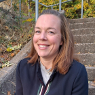 Bilde av Janne Halvorsen, smilende, som sitter i en trapp
