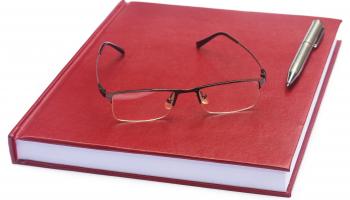 Bilde av rød bok med briller og en penn.
