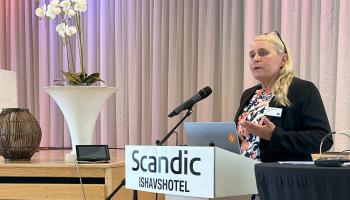 Bilde av Mona Mathisen, ansvarlig redaktør for Utdanning.no på talerstolen.