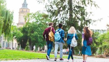 Fire studenter som går mot campus 