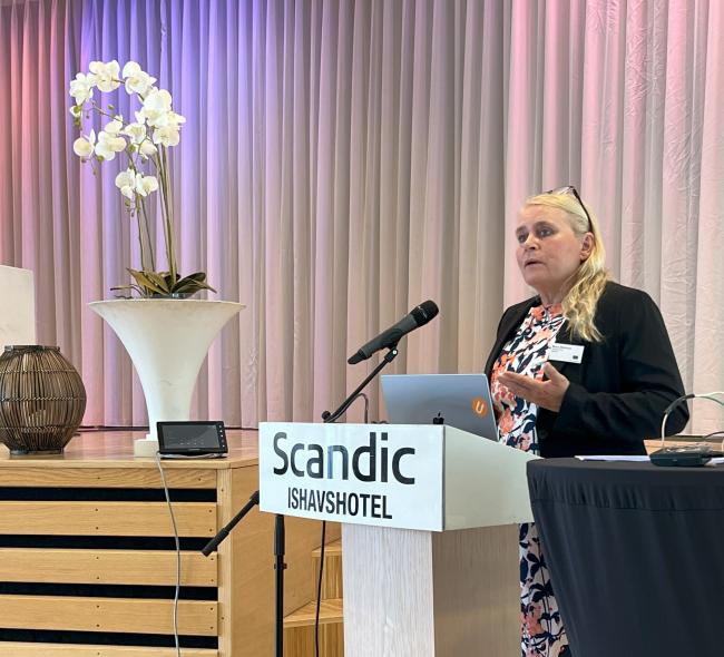 Bilde av Mona Mathisen, ansvarlig redaktør for Utdanning.no på talerstolen.