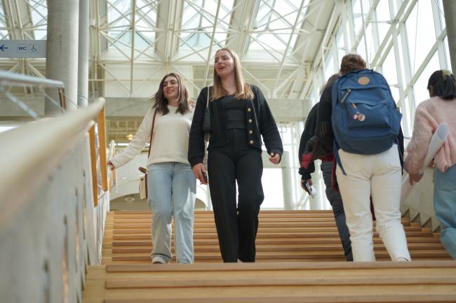 Bilde av smilende studenter i ei trapp på Universitetet i Innlandets avdeling på Lillehammer.