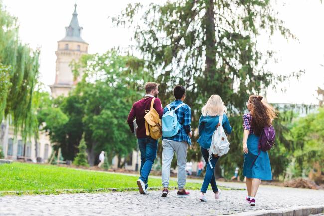 Fire studenter som går mot campus 